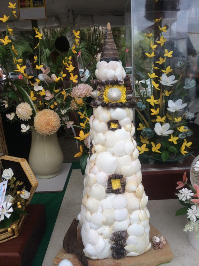 This lighthouse is created with a variety of shells.  Note that the flower petals in the background are also made entirely of shells.