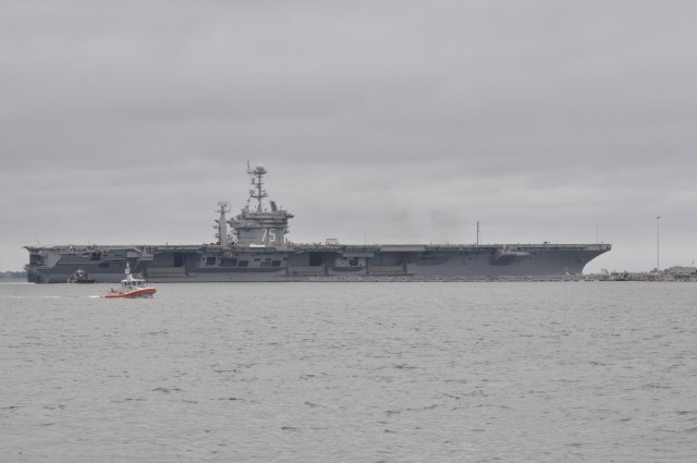 Security vessels make sure that others maintain a wide berth around Aircraft Carrier 75.