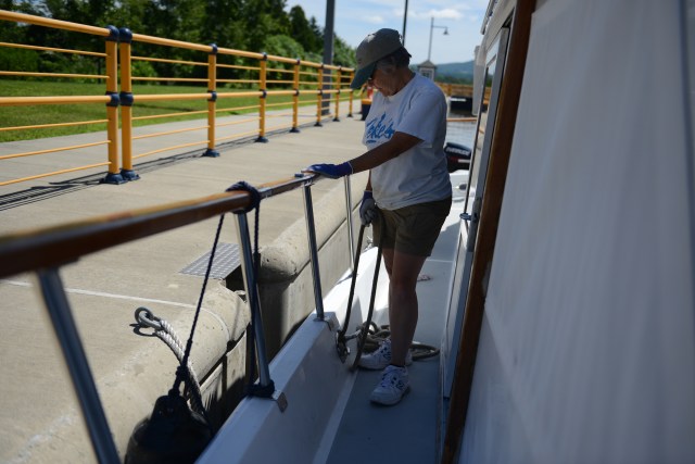 Ann tends the line that helps hold the Traveler steady in the lock.  The line must be continually adjusted as water enters the lock to lift the boat to the higher level.