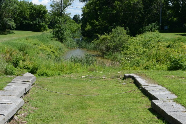 Just behind the upper walls of an original canal lock, is a portion of the 1825 Erie Canal.  You can see that at four-feet deep, it was little more than a ditch.  This little ditch changed forever the economy and the history of of our country.