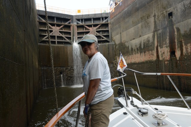 Ann holding the bow line to keep the Traveler safe during a lock passage.